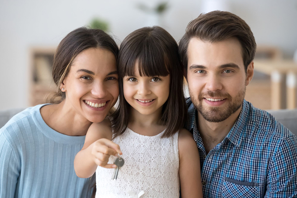 Young family holding keys to a new home